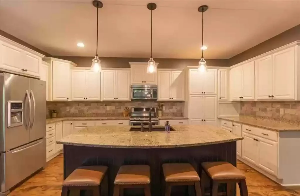 White cabinetry around a large granite kitchen island