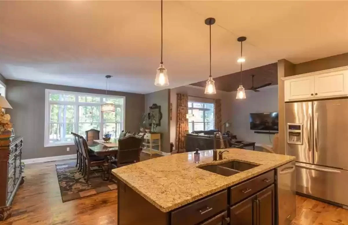 Open kitchen with granite island, pendant lighting and adjacent dining area